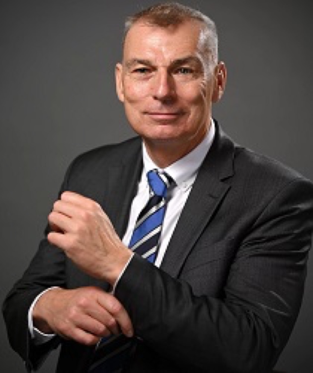 Rechtsanwalt Ulli H. Boldt im Anzug, Portraitaufnahme vor dunklem Hintergrund
